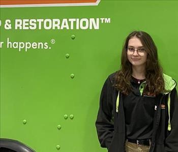 employee smiling in front of SERVPRO truck