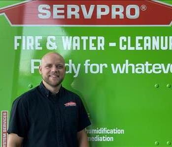Male project manager smiling in front of SERVPRO truck