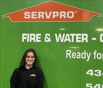 employee smiling in front of SERVPRO truck